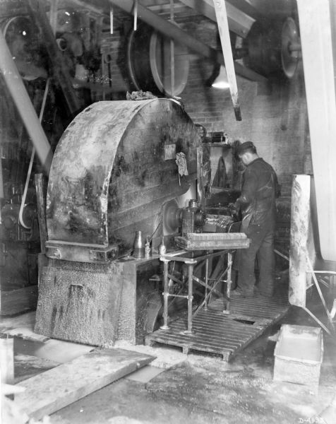 Man working with a large grinder at International Harvester's Deering Works (factory). The factory was owned by the Deering Harvester Company before 1902, when it became part of International Harvester. The factory was located at Fullerton and Clybourn Avenues.