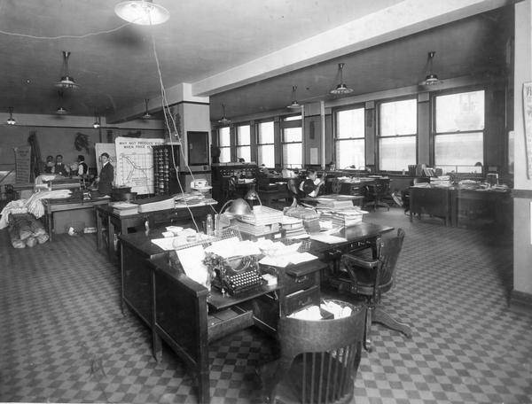 Employees working with lecture charts and films in an International Harvester Agricultural Extension Department office.