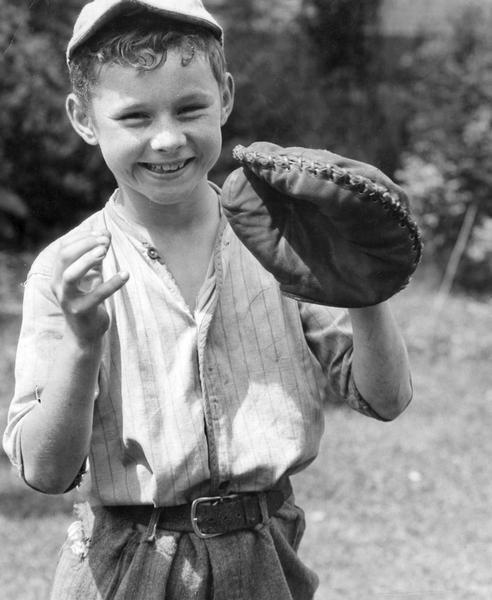 Young Robert Bailey, son of Mr. and Mrs. J.B. Bailey, holding up a baseball catcher's mitt.