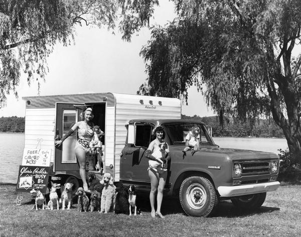 Gloria Peebles (left), animal trainer, Kay Bliss (right), assistant, and their Busy B's canine act performers (11 dogs and 2 monkeys) in front of International 1200D pickup.