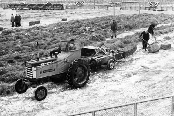 Farmall 460 tractor with windbreaker and no. 46 baler removing twenty tons of hay from Green Bay City Stadium (now Lambeau Field) at 9 a.m. on the day of the National Football League (NFL) championship game between the Green Bay Packers and the New York Giants. The hay, which formed a one-foot padding on top of the field tarpaulin, had been on the field for weeks to protect it. The Packers went on to defeat the Giants 37-0.