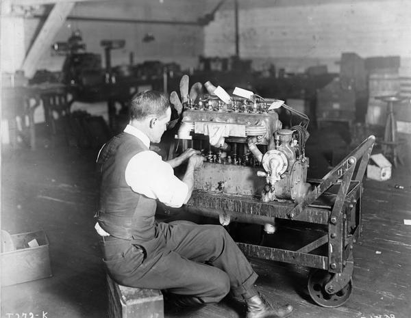 Man working on an inline truck engine at International Harvester's Akron Works. The factory was owned by the Aultman & Miller Buckeye Company until the company was purchased by International Harvester in 1905. The factory burned in 1907 but was rebuilt in 1912.
