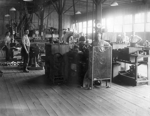 Workers in a machine shop(?) at International Harvester's Akron Works. The factory was devoted primarily to the manufacture of trucks. The works originally belonged to the Aultman & Miller Buckeye Company until it was bought out by IHC in 1905. Retooled and modernized in 1907, the works unfortunately burned and was rebuilt in 1912. Occupying 11.5 land acres, the works closed in 1919 when truck manufacturing was moved to Springfield Works. Products manufactured: harvesters (Buckeyes, until 1906 or so), auto wagons, commercial cars, motor truck parts, tractors (until 1911).