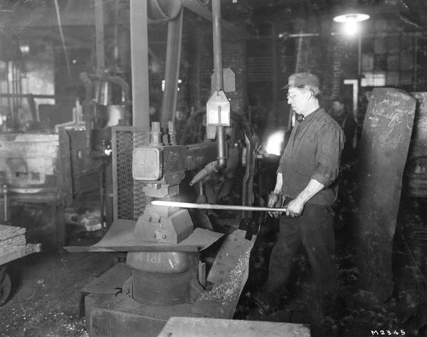 Worker forming the tip of a steel rod at International Harvester Milwaukee Works. The factory was owned by the Milwaukee Harvester Company until 1902.