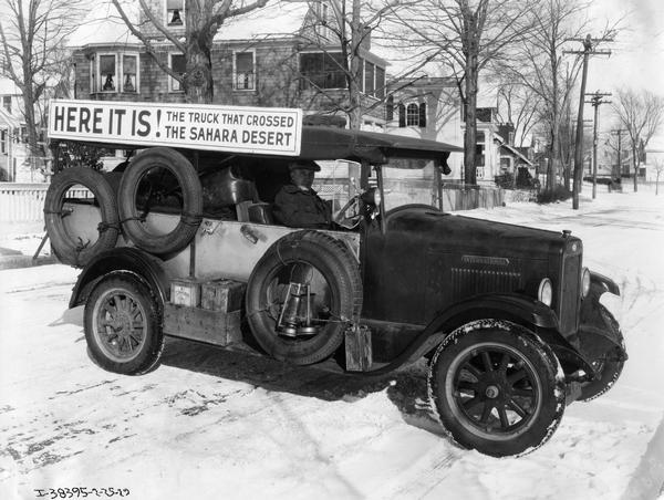International Special Delivery truck on a snowy street in the Midwestern United States. The truck bears a sign that reads "Here it is! The truck that crossed the Sahara Desert." The truck was the first stock, four wheel motor vehicle to cross the Sahara Desert between December 1927 and April 1928. The trip started in Nairobi, Kenya. There the truck was outfitted with a special body and loaded with provisions such as a five gallon can of oil, one of water, and 76 gallons of gas. From there the truck traveled northwest for 3,800 miles over barren terrain and through rivers until it reached Kano, Nigeria. The driver, Mr. C.N. King, worked for the International Harvester Export Co. He was accompanied by a priest who wanted to visit mission stations along the way. The trip took 19 days, with the truck averaging 18.09 miles per gallon. At Kano, in March 1928, the truck was sold to two explorers who drove it north across the Sahara to Algiers. Sixteen days and 2,818 miles later, Sir Charles Markham and his companion, a Swede named von Blixen-Finecke arrived in Algiers. The truck subsequently toured the United States as part of an International Harvester publicity campaign.