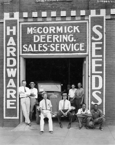 Employees of a McCormick-Deering dealership posing at the service entrance with an International truck.