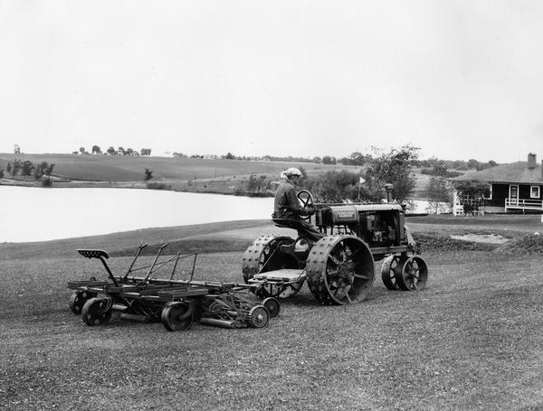 Rear view of man cutting grass at the Chariton Golf Club with a Fairway tractor and mower. The tractor is the Farmall Regular version of the Fairway.