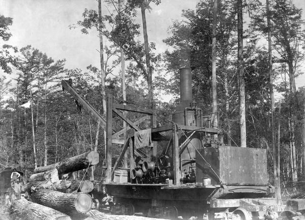 Steam crane loading lumber onto a railroad car for use at an International Harvester sawmill.