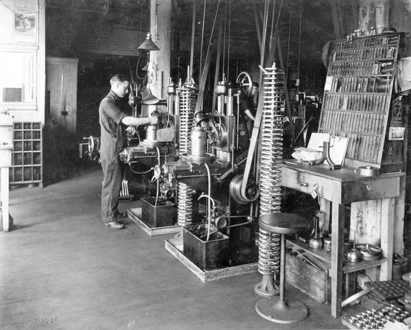 Factory worker operating a gear cutting machine at International Harvester's Milwaukee Works. The gears were used for Lily cream separators. The factory was owned by the Milwaukee Harvester Company until 1902.