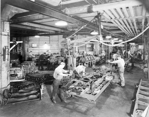 Workers on an assembly line installing front and rear axles on a truck frame at International Harvester's Chatham Works in Ontario, Canada. The factory was owned by the Chatham Manufacturing Company until 1910. The factory produced wagons and sleighs until 1935. In 1921 the factory began manufacturing trucks.