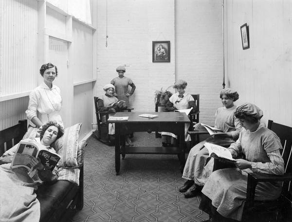 Female workers and an attendant reading magazines and relaxing inside a "rest room" at International Harvester's Osborne Twine Mill. The Osborne Works was located at 5 Pulaski Street. It was owned and operated by D.M. Osborne and Company until the company was purchased by International Harvester in 1903.