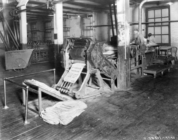 Workers stitching and printing labels on burlap bags used to store balls of binder twine at International Harvester's McCormick Twine Mill. The McCormick works was in operation from 1873 to 1961 and was located at Blue Island Avenue and Western Avenue in the Chicago subdivision called "Canalport."