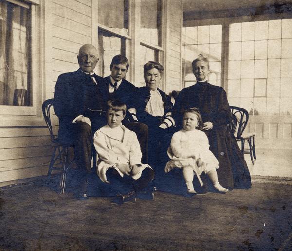Group portrait of Rockefeller and McCormick families. Pictured are (L to R): John D. Rockefeller, Sr., unidentified young man, Mrs. John D. Rockefeller, Sr., Nettie Fowler McCormick. Seated in front are the grandchildren "Fowler" (Harold McCormick Jr.) and his sister, Muriel.