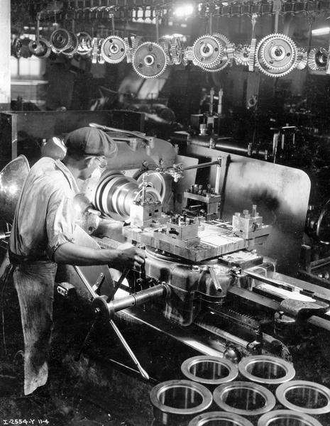 Worker machining a TracTracTor (crawler tractor) track roller shell with a turret lathe at International Harvester's Milwaukee Works.