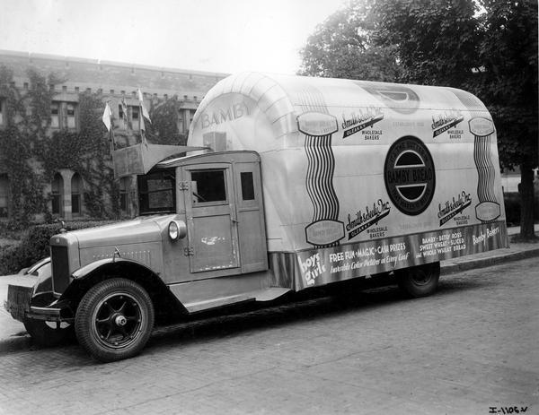 International bakery truck, with modified body to make it look like a loaf of bread, advertising Bamby bread. The truck was owned by Smith and Seely Inc., wholesale bakers of Olean, New York. Signs painted on the truck reads: "It's the Butter in Bamby Bread that makes it better", Smith & Seely Inc., Olean, N.Y." and "boys girls Free Fun * Magic * Cash Prizes Invisible Color Pictures in Every Loaf".
