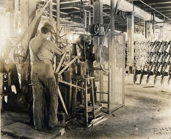 Worker assembling the spokes of a wooden wagon wheel at International Harvester's Weber Wagon Works in Auburn Park. The factory was owned by the Weber Wagon Company until 1904, when it was purchased by International Harvester.