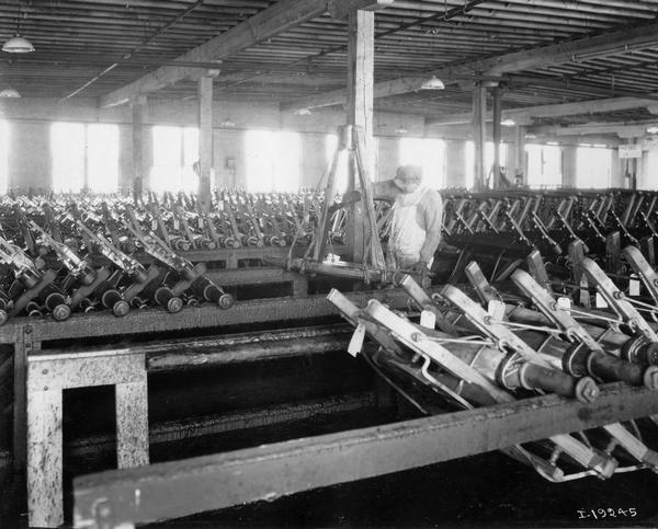Worker painting wagon trucks at International Harvester's Weber Wagon Works in Auburn Park. The factory was owned by the Weber Wagon Company until 1904, when it was purchased by International Harvester.