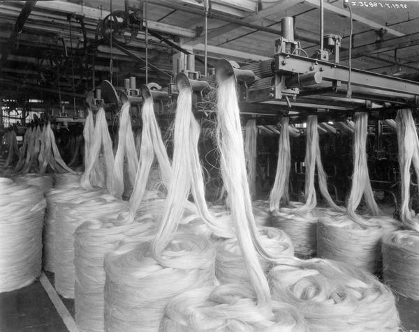 Spools of fiber feeding into machines for making twine at International Harvester's Hamilton Twine Mill, Hamilton, Ontario, Canada.