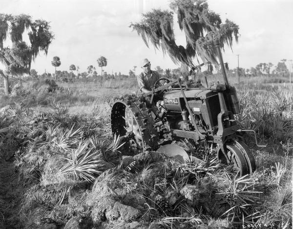 Man plowing palmetto land with McCormick-Deering Farmall F-12 and Hester side plow.