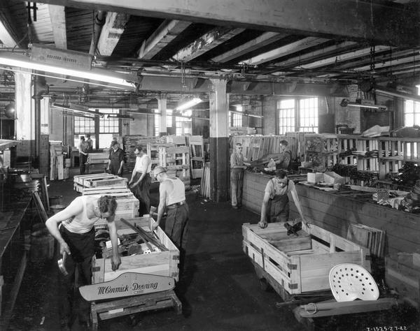 Workers boxing McCormick-Deering mowers for shipment inside the packing department at International Harvester's McCormick Works. The factory was built in 1873 and was located at Blue Island and Western Avenues in the Chicago subdivision called "Canalport." It closed in 1961.