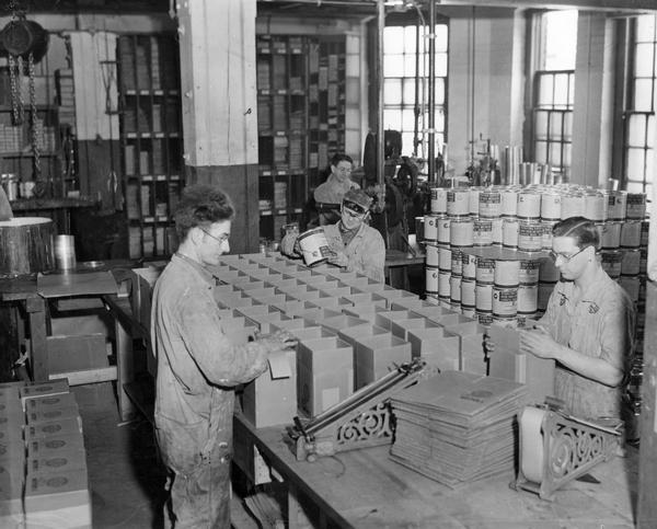 Paint Department workers boxing cans of "Motor Truck and Tractor Synthetic Enamel Paint" for shipment from the International Harvester's McCormick Works. The McCormick Works was built by Cyrus McCormick in 1873 and became part of International Harvester in 1902. The factory was located at Blue Island and Western Avenues in the Chicago subdivision called "Canalport." It was closed in 1961.