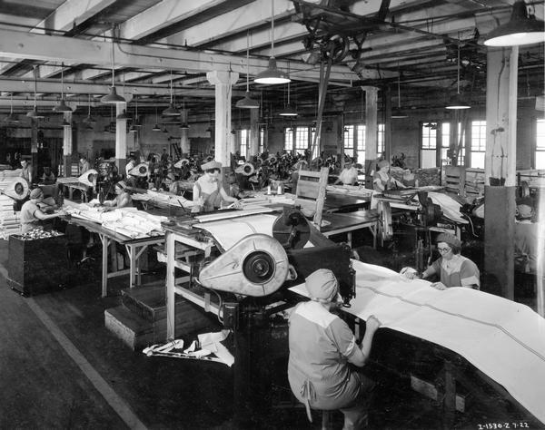 Female workers sewing canvas side folds on binder aprons at International Harvester's McCormick Works. The McCormick Works was built by Cyrus McCormick in 1873 and became part of International Harvester in 1902. The factory was located at Blue Island and Western Avenues in the Chicago subdivision called "Canalport." It was closed in 1961.