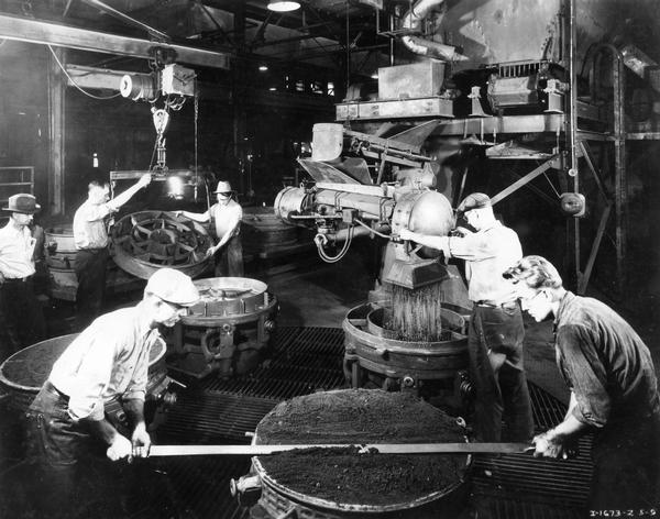 Workers making molds for castings with new sand conveyor units inside the foundry of International Harvester's McCormick Works. The McCormick Works was built by Cyrus McCormick in 1873 and became part of International Harvester in 1902. The factory was closed in 1961.