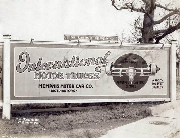 Roadside billboard for International motor trucks distributed by the Memphis Motor Car Company. The advertisement depicts an International truck axle.