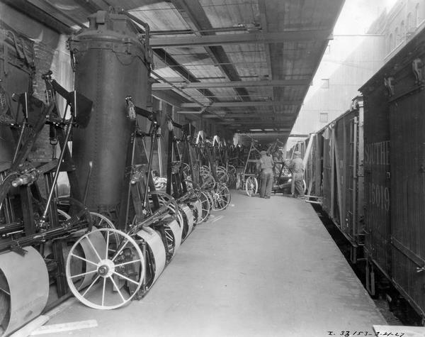 Workers loading new folding stubble pulverizers onto railroad cars at International Harvester's McCormick Works. The factory was owned by the McCormick Harvesting Machine Company before 1902. It was located at Blue Island and Western Avenues in the Chicago subdivision called "Canalport."