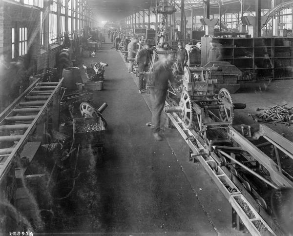Factory workers assembling International 8-16 tractors on an assembly line at International Harvester's Tractor Works.