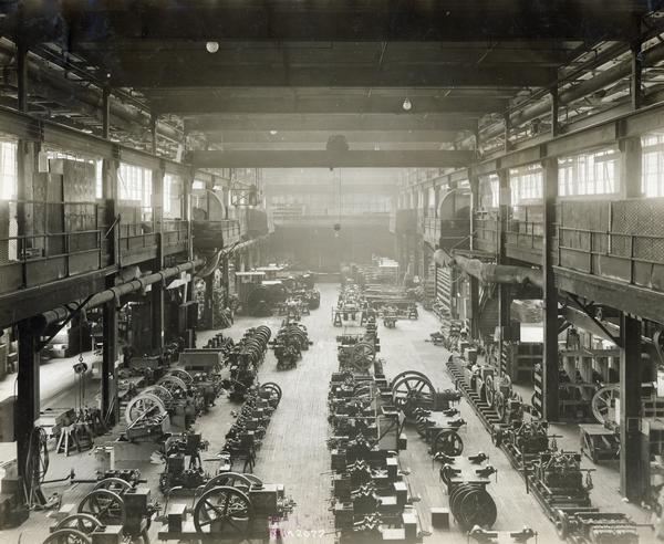 Elevated view of assembled tractors, engines and parts on the erecting floor at International Harvester's Milwaukee Works. The factory was owned by the Milwaukee Harvester Company before 1902.