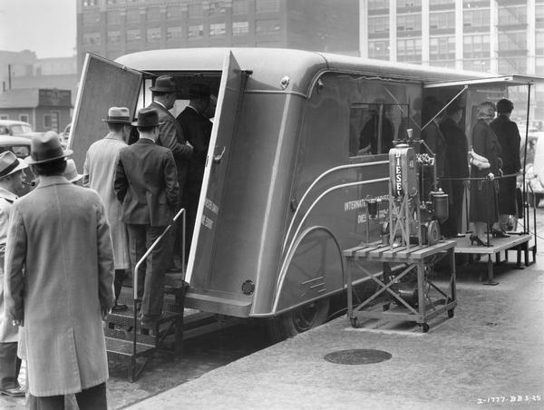 Visitors entering the trailer of International Harvester's touring diesel engine exhibit.