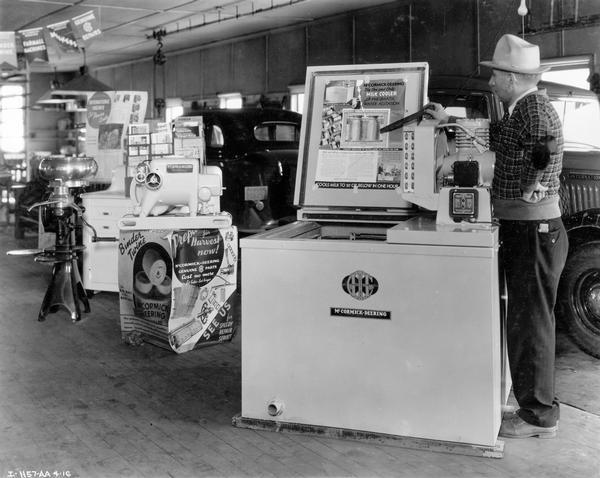 Dealer pointing out the features of a McCormick-Deering milk cooler at the dealership of Wisehaupt Sons & Co. Also pictured are a McCormick-Deering Type LA engine, cream separator and International truck.