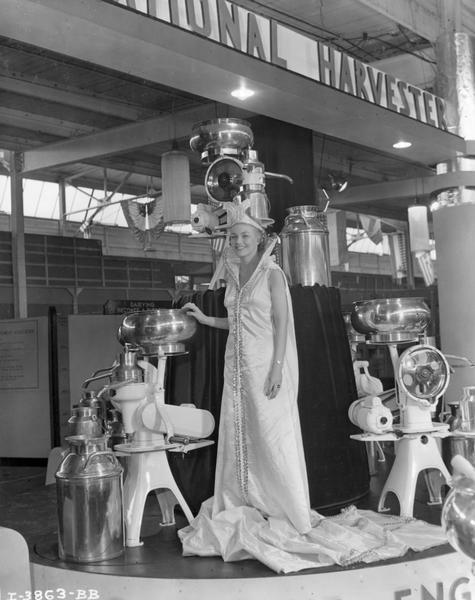 Miss America Marilyn Meseke posing with International Harvester cream separators at the National Dairy Show.
