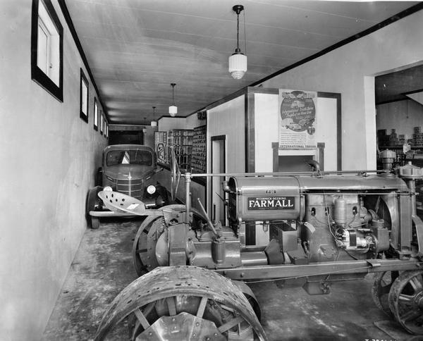 Cramped quarters during a modernization project inside the Parts department and showroom of the  International Harvester dealership of Marshall Moore. A Farmall F-30 tractor and International D-series truck are packed into a tight space near the parts counter as the store pursues a modernization project.