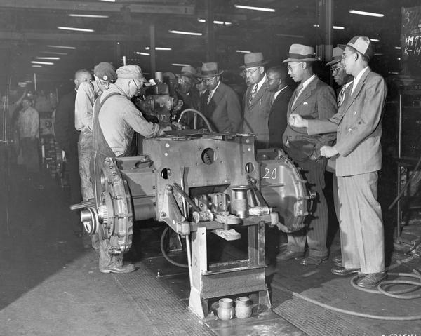Twenty-five members of the "Negro Farmers of America" tour a crawler tractor (TracTracTor) assembly line at International Harvester's Tractor Works. The factory was located at 2600 West 1st Boulevard.