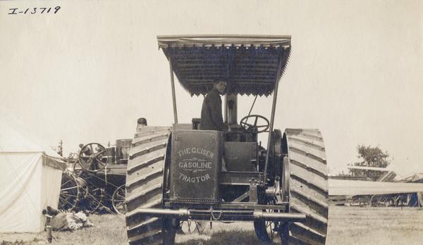 Man standing in a Geiser gasoline tractor at the Winnipeg tractor contest in Canada.