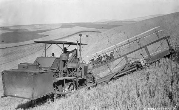 Farmers harvesting with a combine on hilly terrain with a horse-drawn no. 7 Hillside combine on the farm of J.B. McMurray.