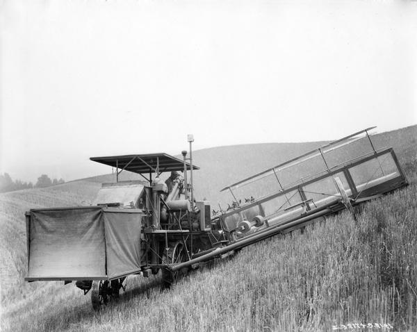 Farmers harvesting grain with a horse-drawn McCormick-Deering no. 7 Hillside harvester-thresher (combine). The hillside machine incorporated a leveling device on the outer wheel that could be changed at any time as was required, while the header was free to pivot to accommodate varying slopes. Taken on the farm of Mr. Joy McGuire.