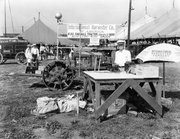 Attendant posing with a radio-operated Farmall F-30 tractor at the Indiana State Fair.