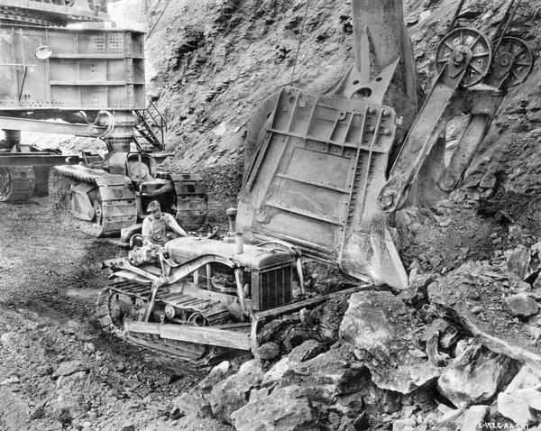 Worker moving rock at the Sahara Mine with an International T-40 TracTracTor (crawler tractor) equipped with a Bucyrus-Erie bullgrader.