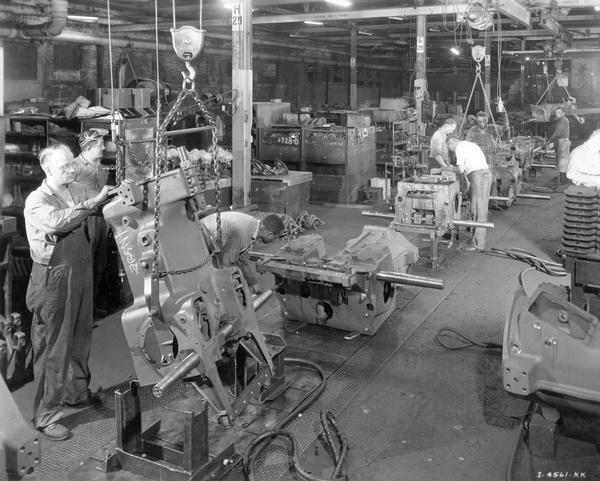 Workers assembling crawler tractor (TracTractor) frames at the beginning of an assembly line at International Harvester's Tractor Works. The factory was located at 2600 West 1st Boulevard.