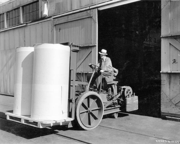 Worker Harry Straka transporting two large drums of paper with an International I-12 powered fork-lift at Oceanic Terminals wharf. The fork-lift was one of twelve Hyster units operated by the Western Transportation Company, a subsidiary of Crown Willamette Paper Company.