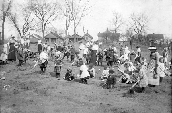 Large group of students and teachers working in the Tyler School Gardens. The director of the school (or gardens?) was E.M. Bardwell.
