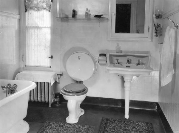 Bathroom with tub, sink, mirror, and toilet in a house on the Harvester Farm.