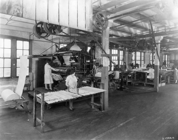 Female workers inserting wooden slats into canvas for grain binders in the McCormick Works Twine Mill. The factory was owned by the McCormick Harvesting Machine Company before 1902.
