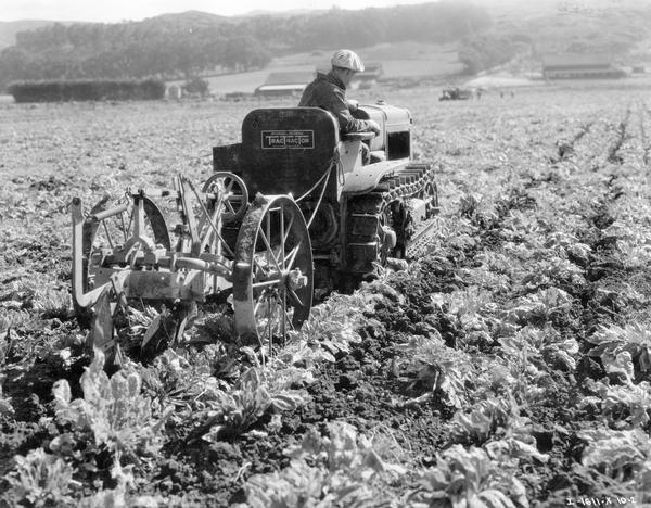 Man pulling a subsoiler with a McCormick-Deering T-20 TracTracTor (crawler tractor). A note with the original print reads: "not a McCormick-Deering subsoiler says San Francisco."