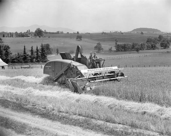 Farmers operating a McCormick-Deering 123-SP combine in a barley field. The combine was owned by Roy Kinsey.