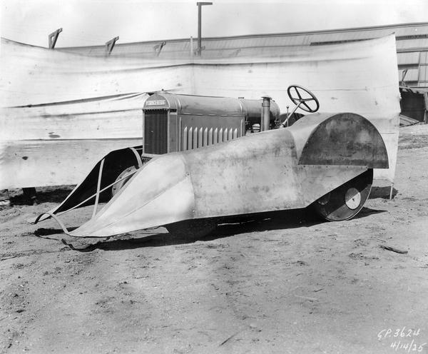 Engineering photograph of an experimental McCormick-Deering tractor with fenders apparently designed for use in orchards or groves. Left side view.