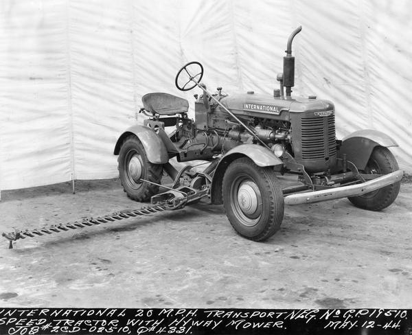 Engineering photograph of an experimental International 20 m.p.h. transport speed tractor with highway mower. The tractor appears to be equipped with International truck tires.